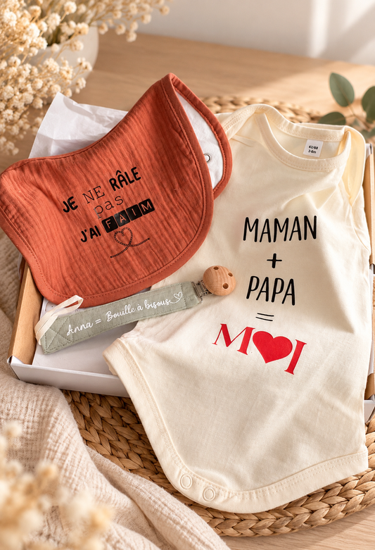 Coffret de naissance personnalisé avec body écru Maman + Papa = Moi, bavoir terracotta Je ne râle pas j'ai faim et attache-tétine en tissu.
